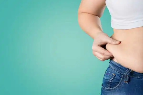 Image of woman pinching her love handles to show weight gain Southam